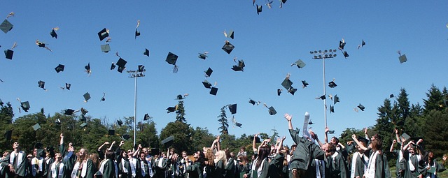 Students throw graduation caps into the air in celebration